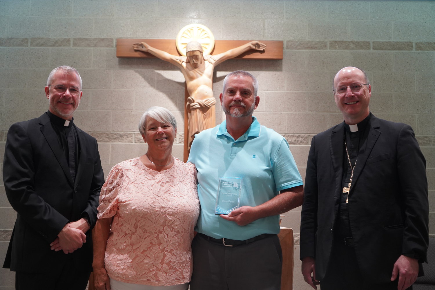 Father Jeremy Secrist, pastor of St. Peter Parish in Jefferson City, parishioners Carol and Dean Dutoi, and Bishop W. Shawn McKnight gather before the altar in the chapel of the Alphonse J. Schwartze Memorial Catholic Center in Jefferson City Aug. 30, after Bishop McKnight presented Mr. Dutoi the Missouri Catholic Conference’s 2022 Citizen Recognition Award for the Jefferson City diocese. Mr. Dutoi served for over a decade as president of St. Peter Parish’s conference of the St. Vincent de Paul Society.